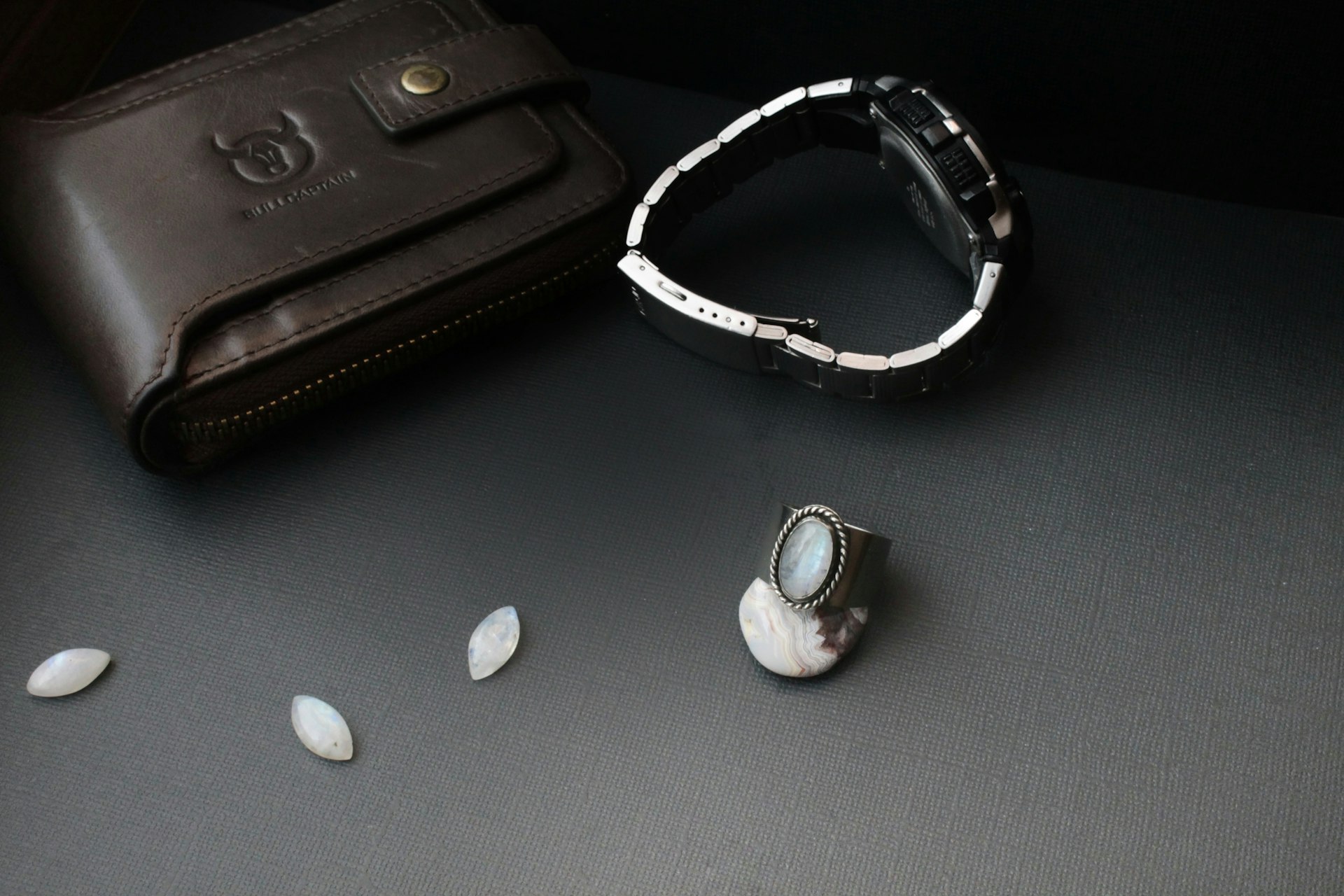 a watch sitting on a table next to a wallet